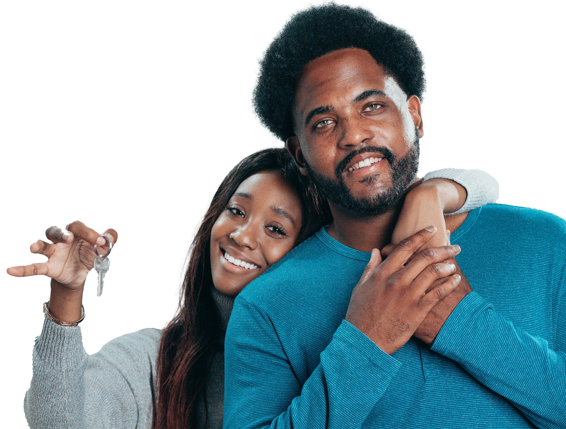 Smiling couple holding keys; woman's arm around man's neck, both wearing sweaters.