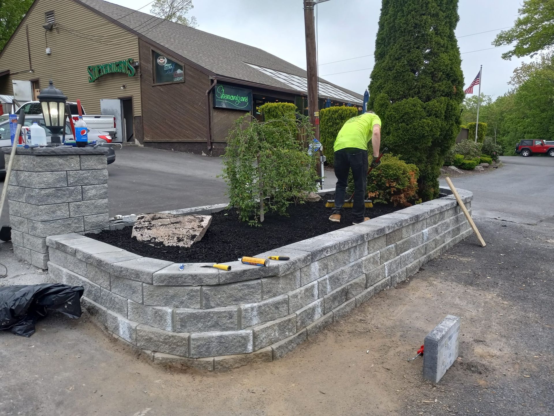 A man is working on a brick wall in front of a building.