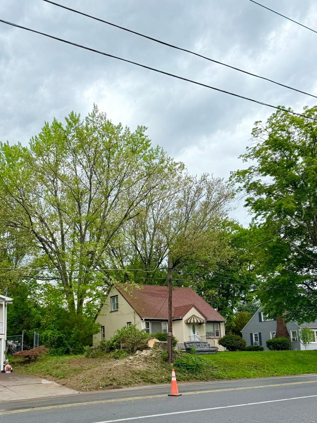 A house with a red roof is sitting on the side of the road.