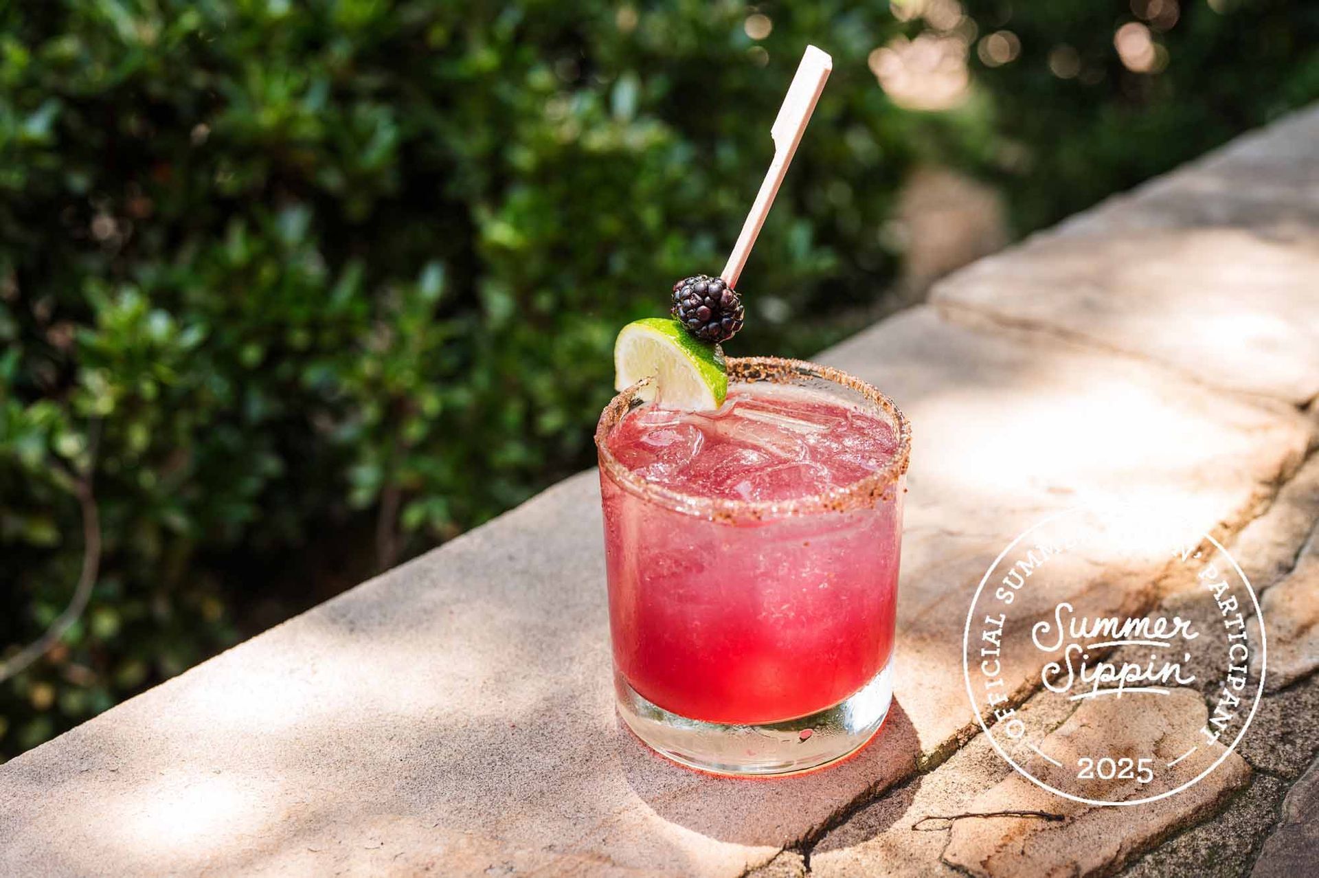 A close up of a plate of food with a glass of wine in the background