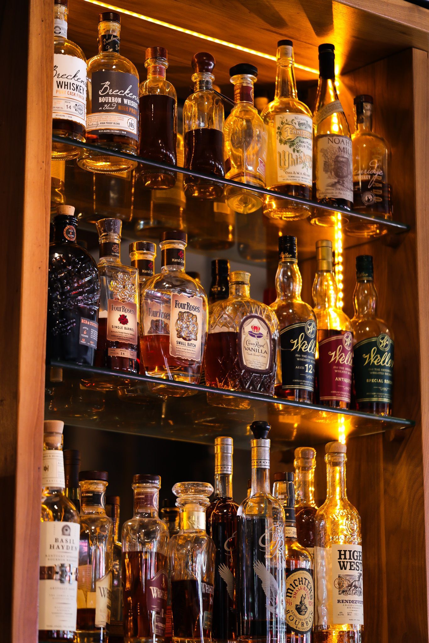 A bar filled with lots of bottles of liquor on shelves.