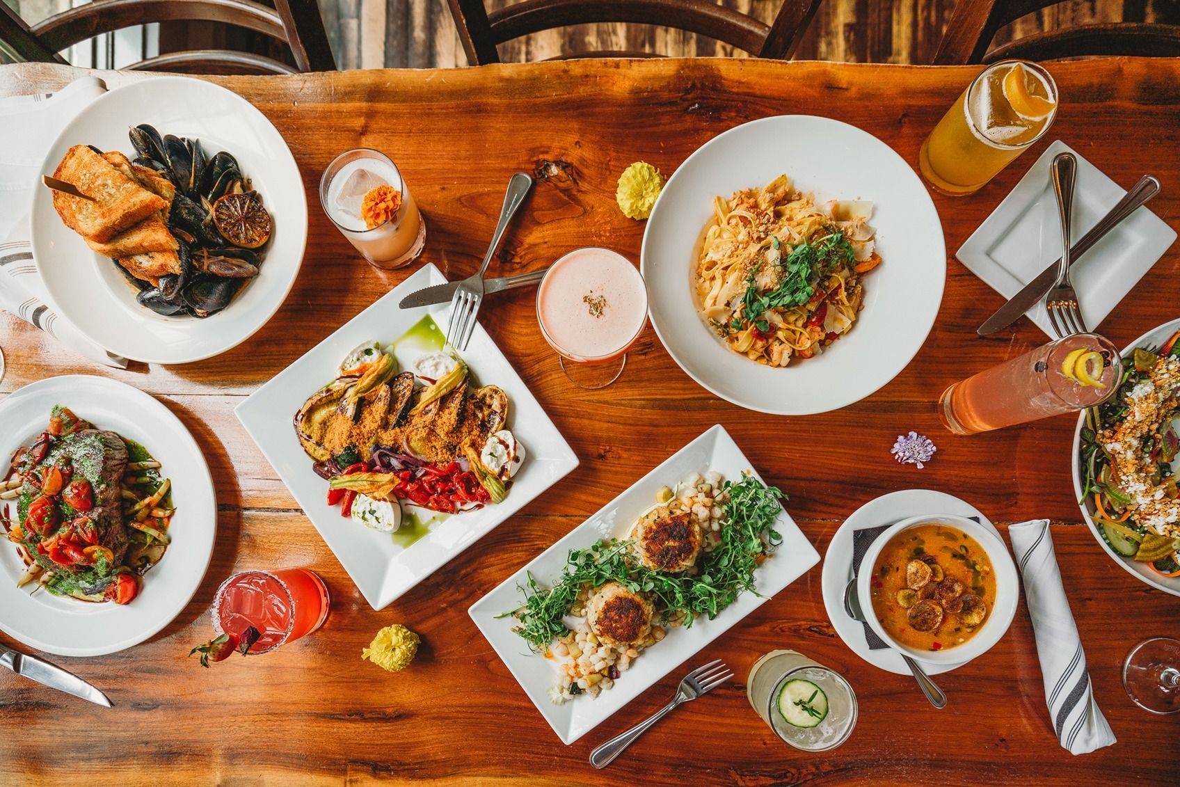 A man in a black shirt is holding two bottles of wine.