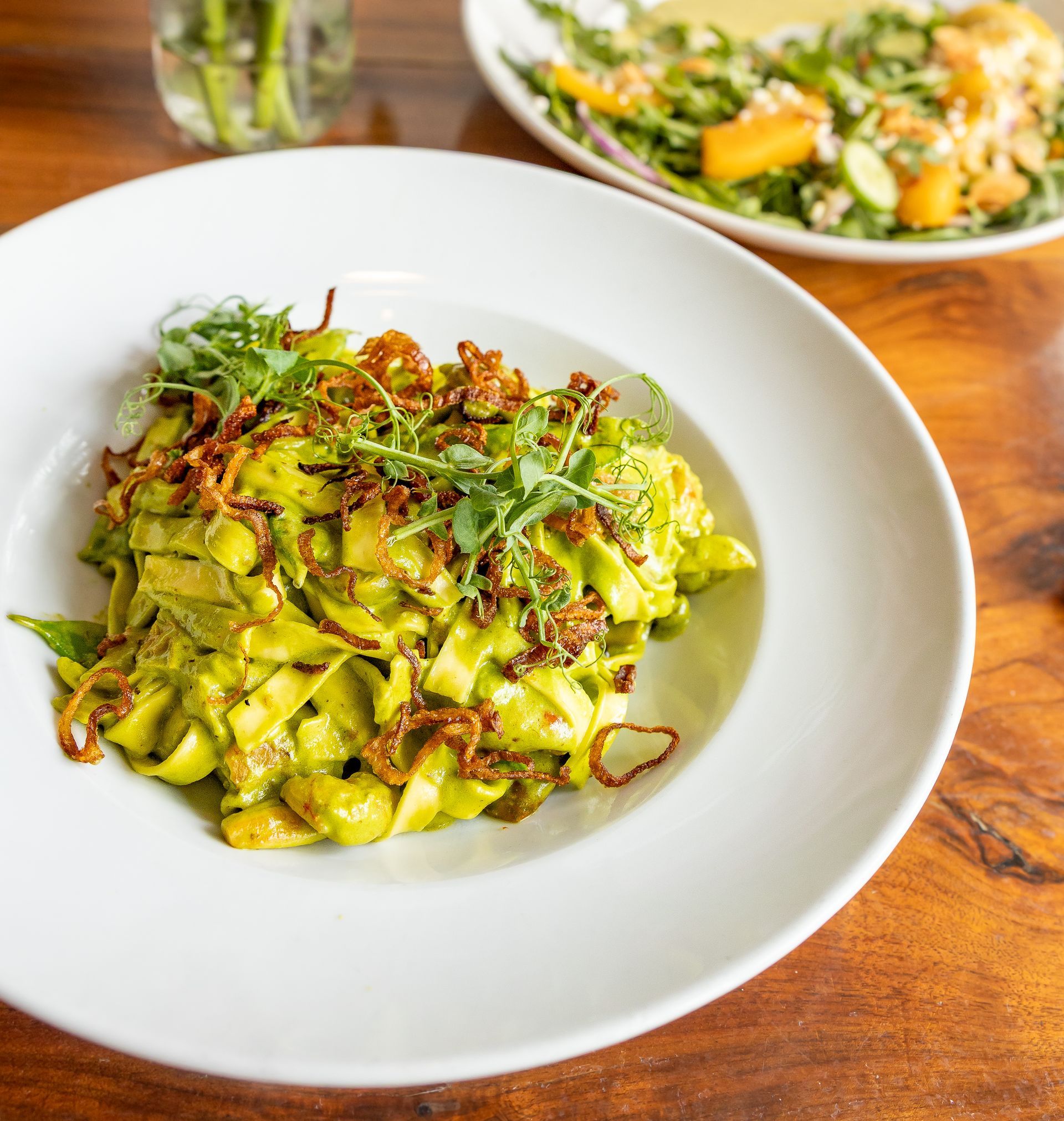 A close up of a plate of food on a wooden table.