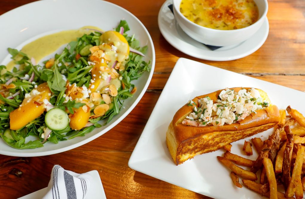 A table topped with plates of food and a bowl of soup.