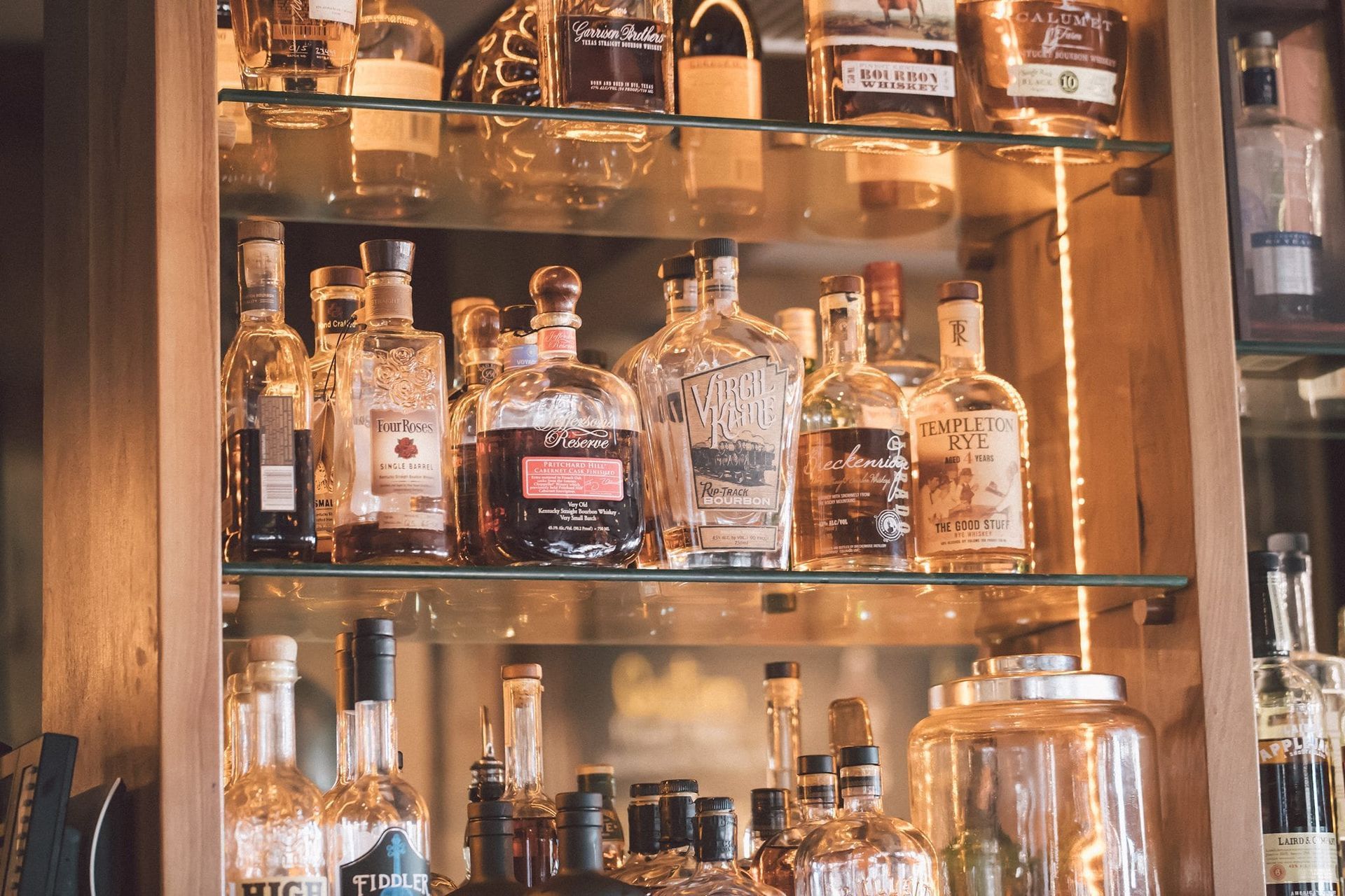 A shelf filled with lots of bottles of liquor.