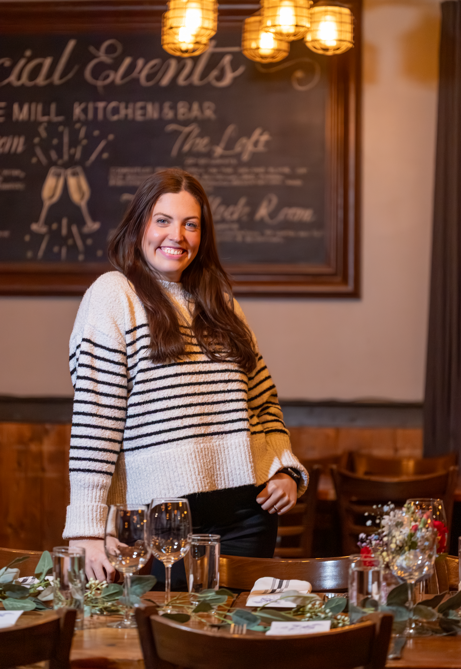A woman in a black shirt is standing in front of a red couch