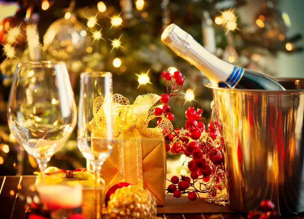 There is a bottle of champagne in a bucket on the table.