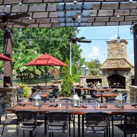 A patio with tables and chairs and a fireplace