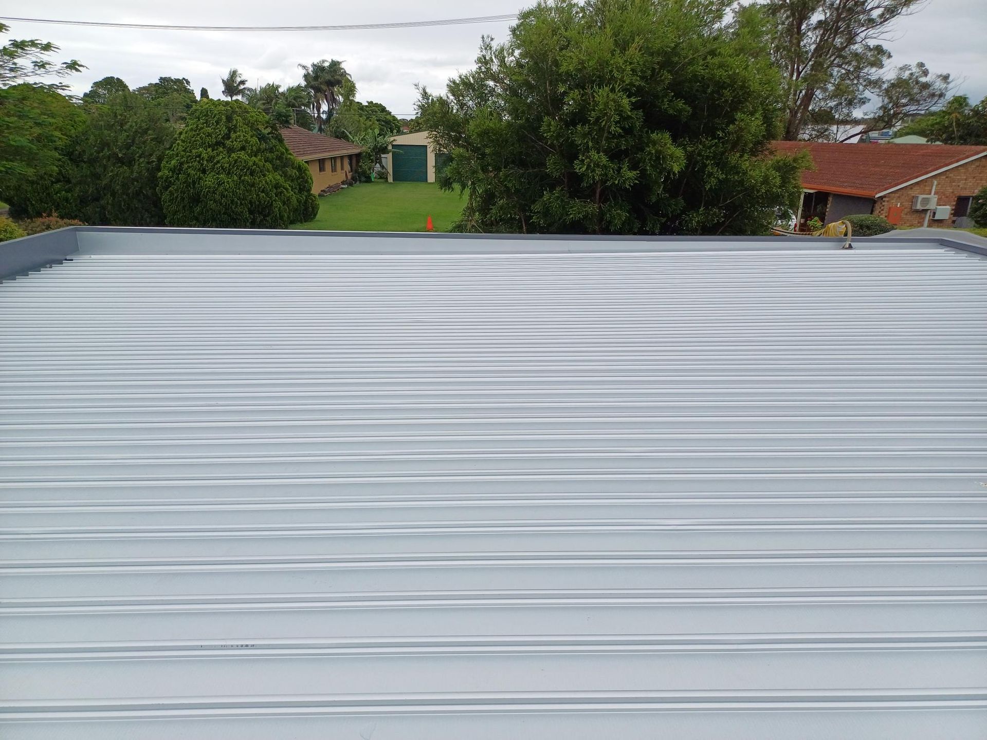 A Close up Of a Gray Metal Roof with Screws on It — Rooftech Roofing Services in Ballina, NSW