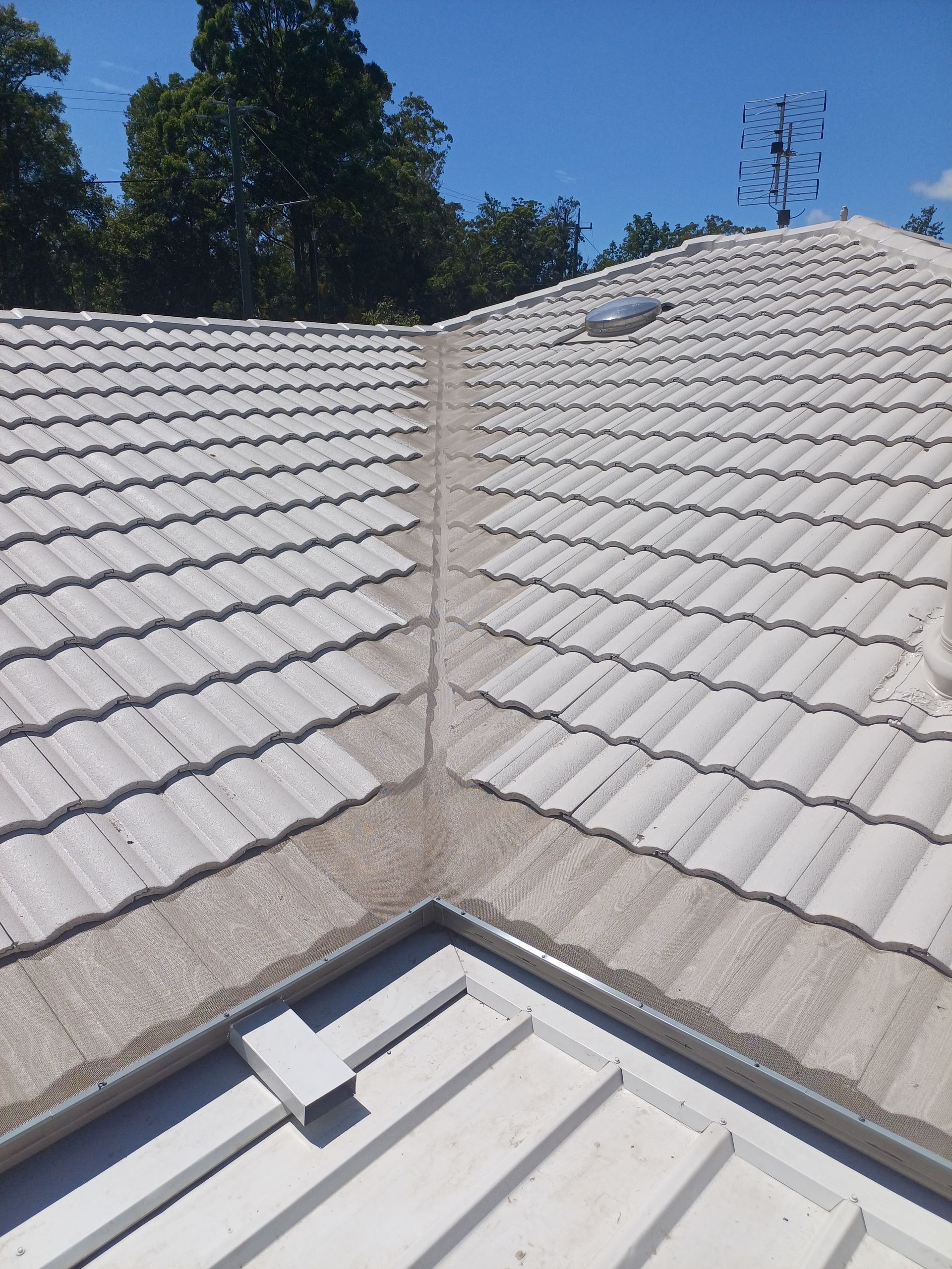 A White Tiled Roof With A Blue Sky In The Background — Rooftech Roofing Services in Byron Bay, NSW