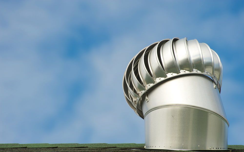 A Metal Exhaust Pipe on Top of A Roof with A Blue Sky in The Background — Rooftech Roofing Services in Ballina, NSW