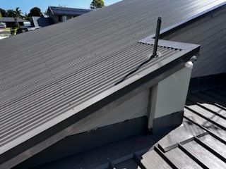 A Grey Metal Roof with A Window on Top of It — Rooftech Roofing Services in Mullumbimby, NSW