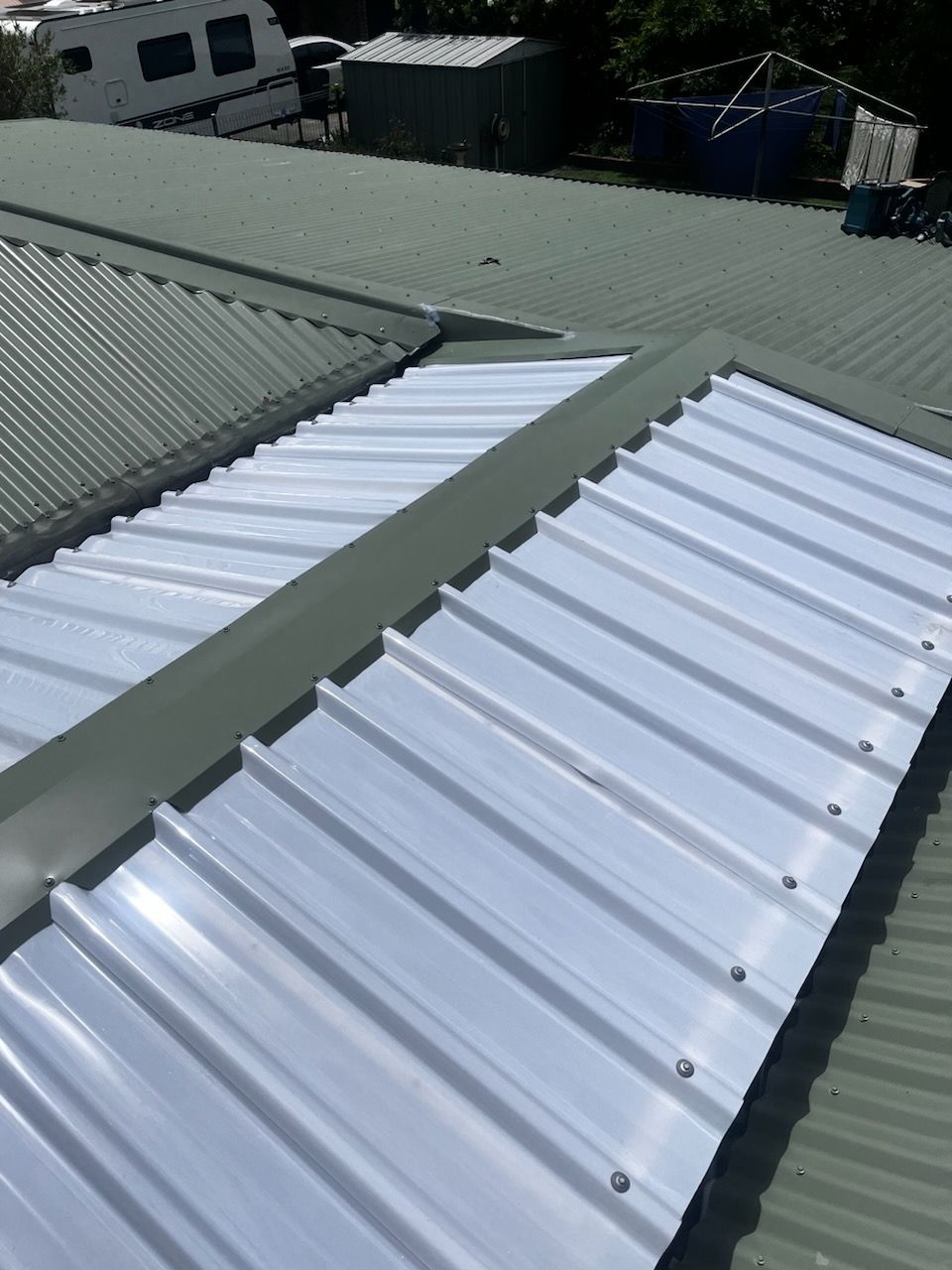 A Close up Of a Green Metal Roof with Screws on It — Rooftech Roofing Services in Byron Bay, NSW