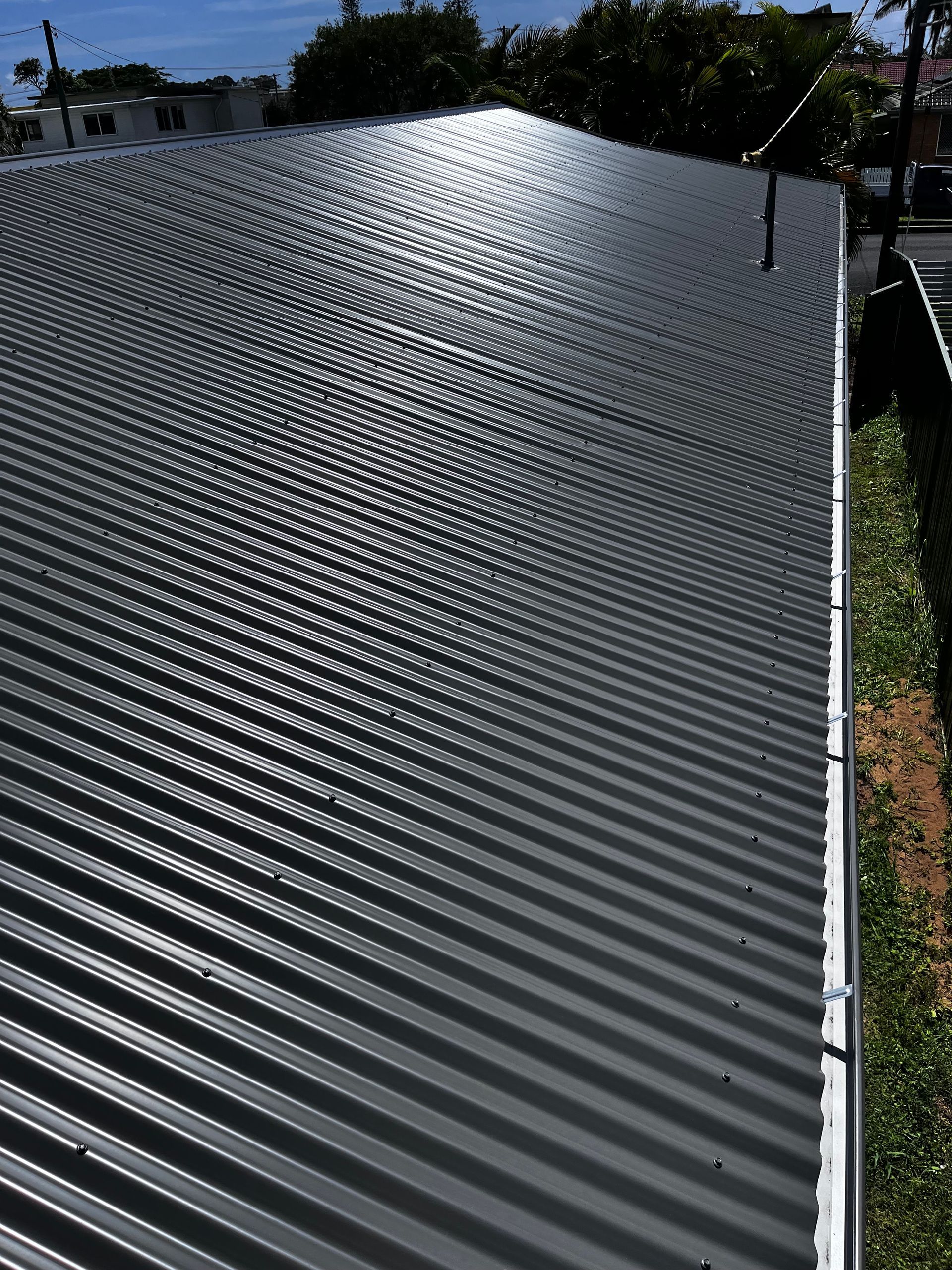 A Close Up Of A Gray Metal Roof With Screws On It — Rooftech Roofing Services in Ballina, NSW