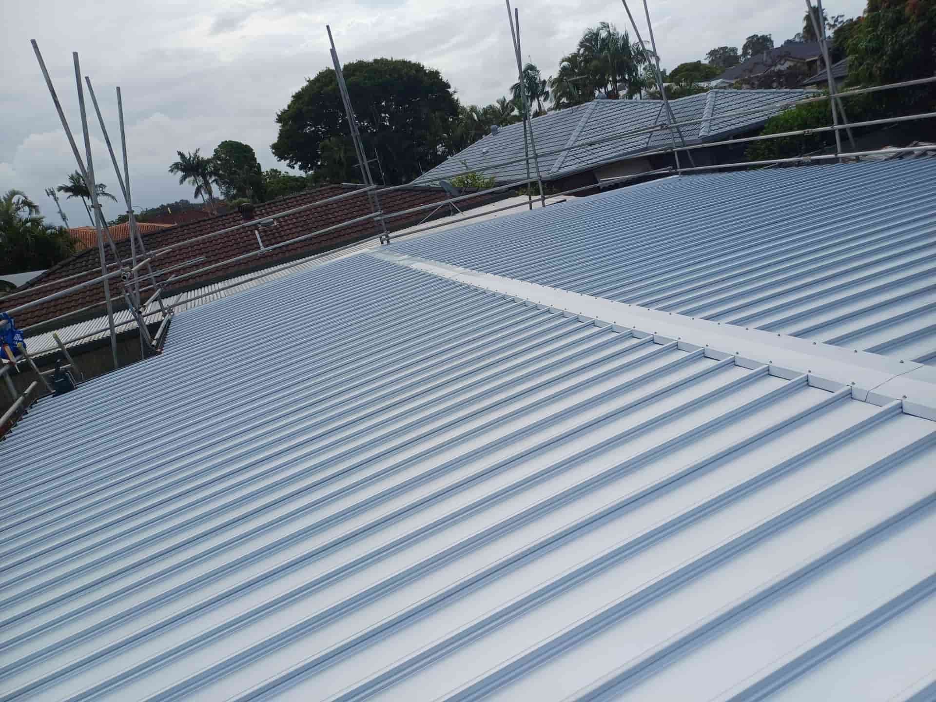 A Light Blue Corrugated Metal Roof, with Safety Scaffolding, Under a Cloudy Sky — Rooftech Roofing Services in Ballina, NSW