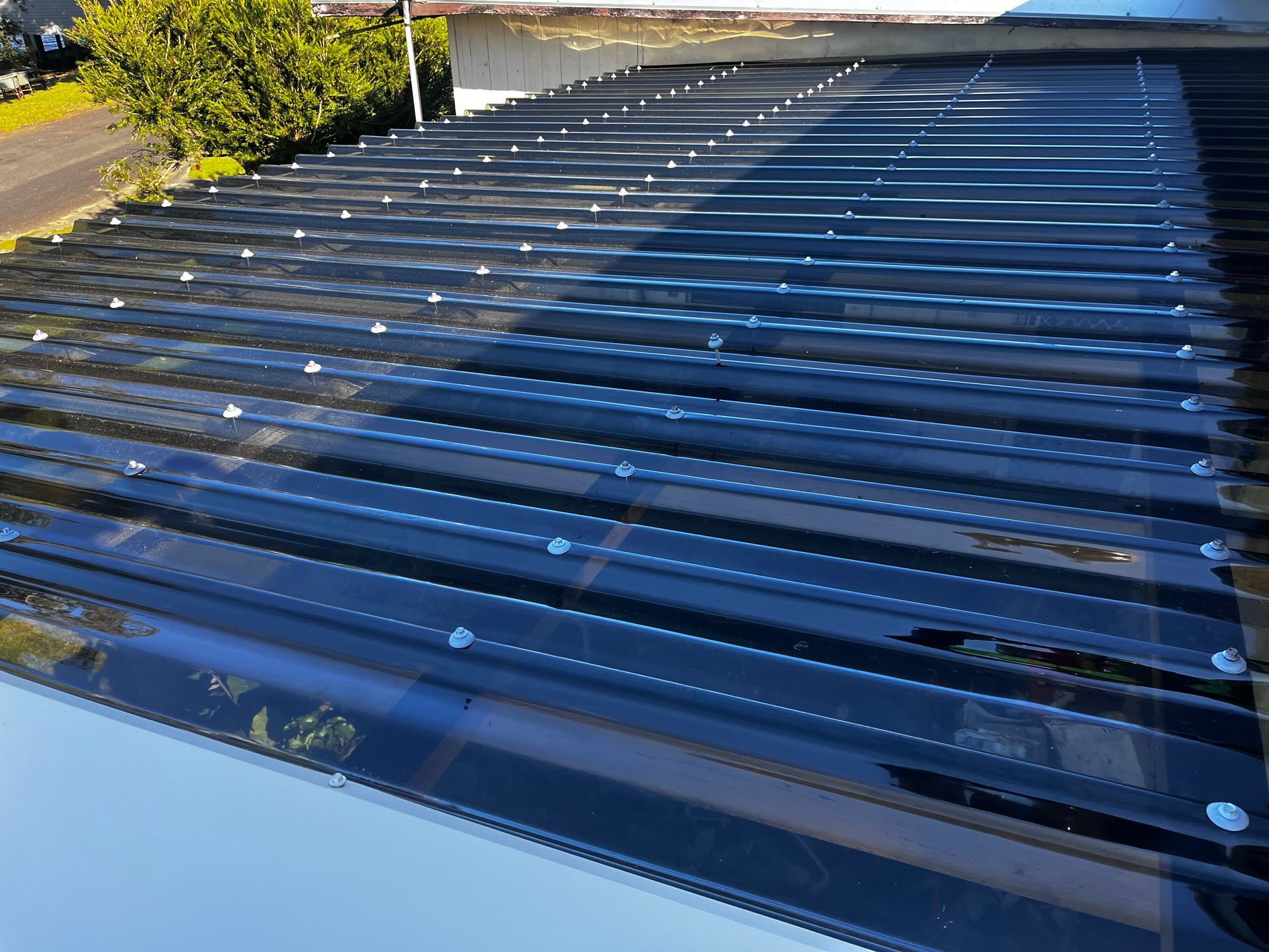 A Close Up Of A Black Roof With A Clear Roof Covering — Rooftech Roofing Services in Casino, NSW