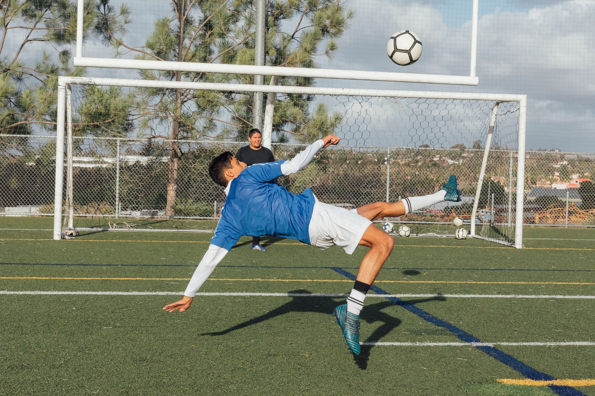 Soccer player kicking ball in midair.
