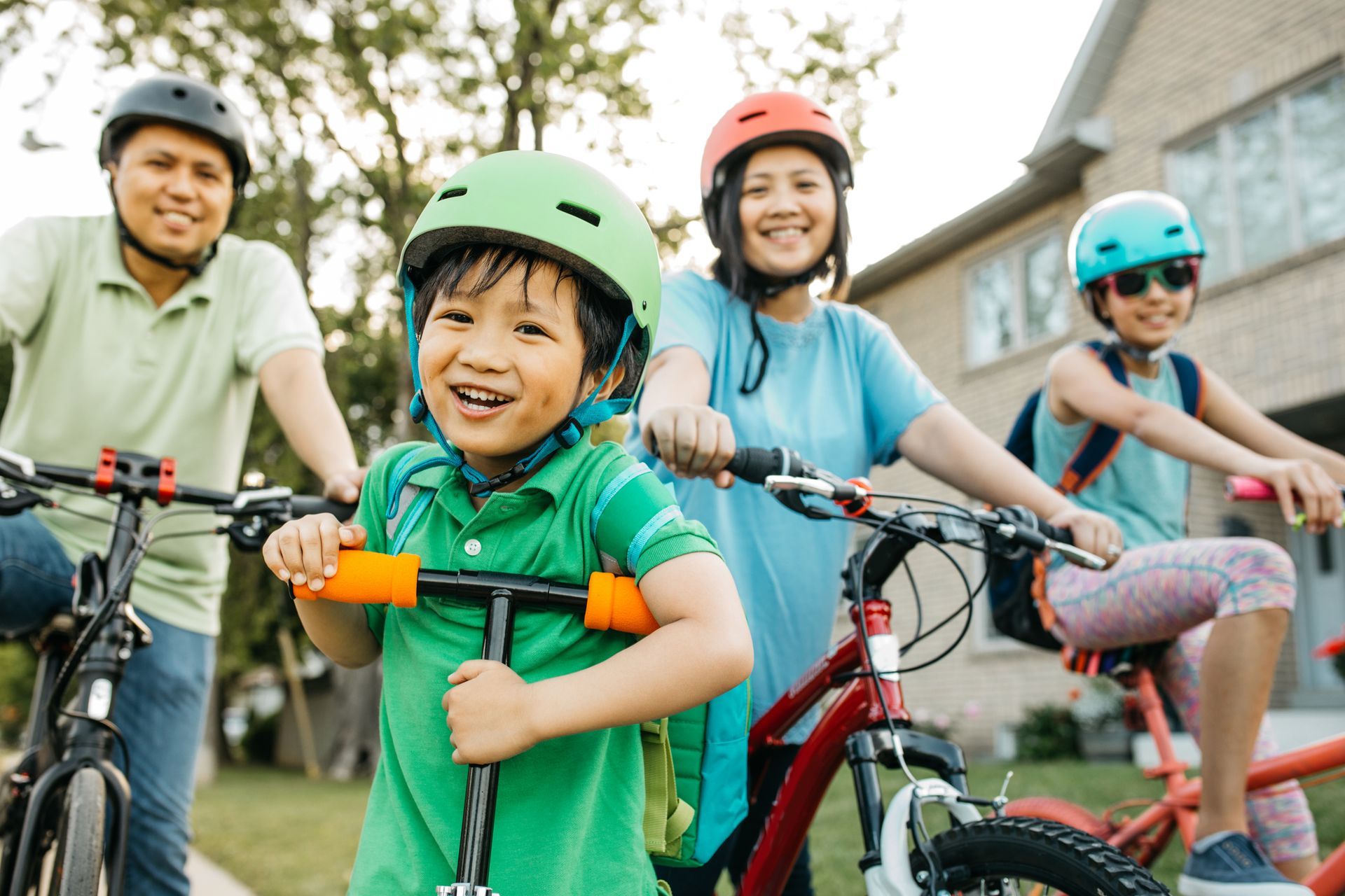 A family of four smiling and riding bikes together on a sunny day. A family of four smiling and riding bikes together on a sunny day.