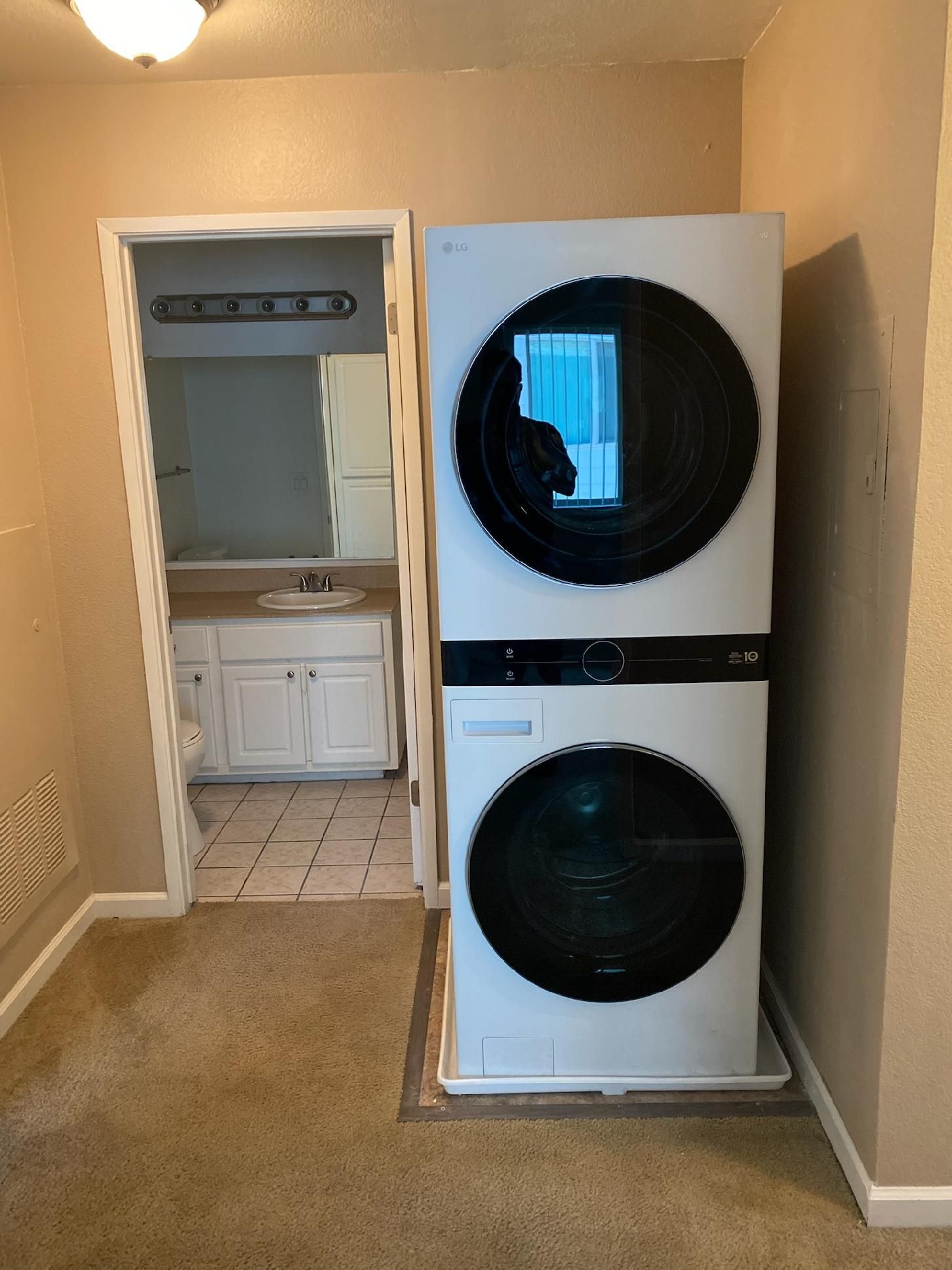 A washer and dryer are stacked on top of each other in a bathroom.