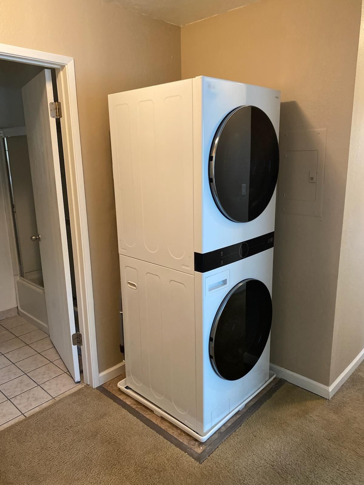 A washer and dryer are stacked on top of each other in a laundry room.