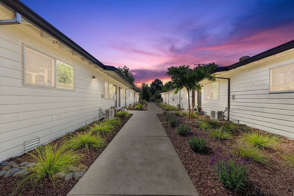 A walkway between two buildings with a sunset in the background.