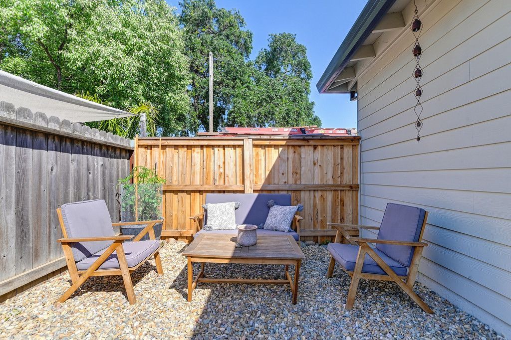 A backyard with a couch and chairs.