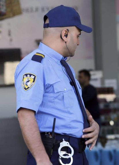 Person in hazmat suit disinfecting a room with fog-like spray; room with clothes rack, sofa, and vase.
