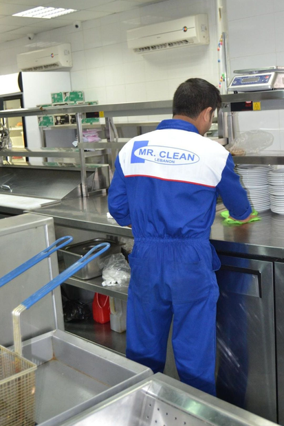 Security guard in blue uniform and cap, wearing an earpiece, looking to the side.