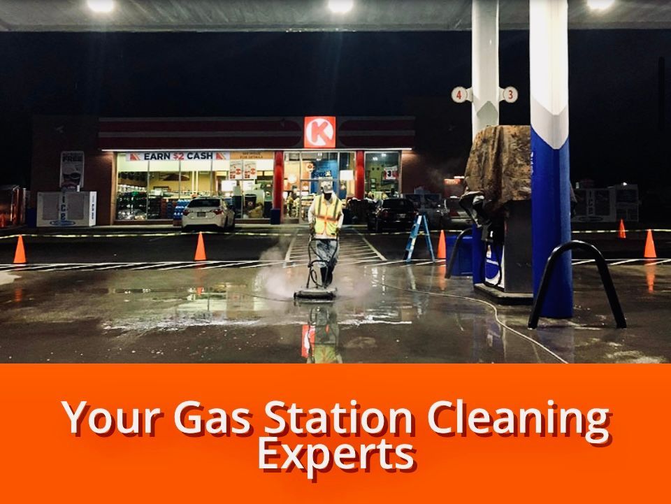 Gas station cleaning at night. Worker using equipment.  Store and gas pumps in background, orange text: 