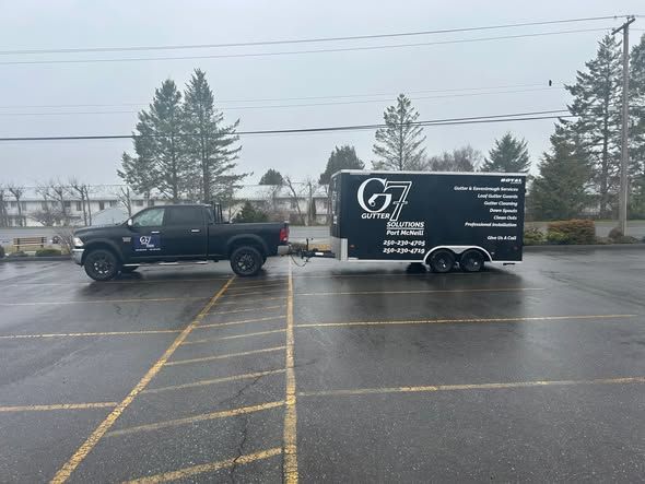 Black pickup truck with trailer parked in a lot. The trailer has a company logo on the side.