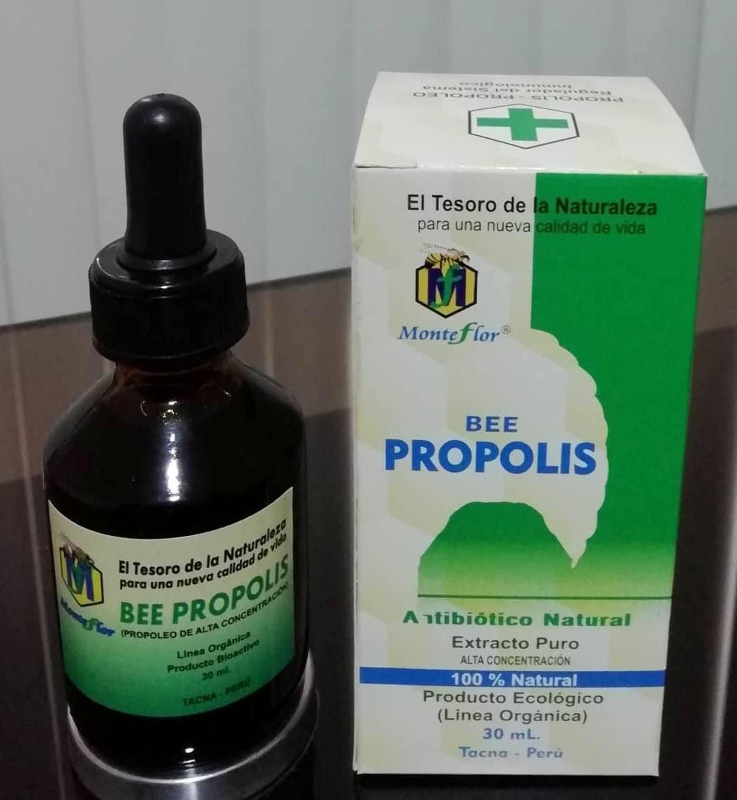 Una botella de propóleo de abeja junto a una caja