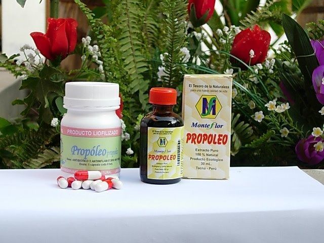 Una botella de propóleo junto a una botella de pastillas.