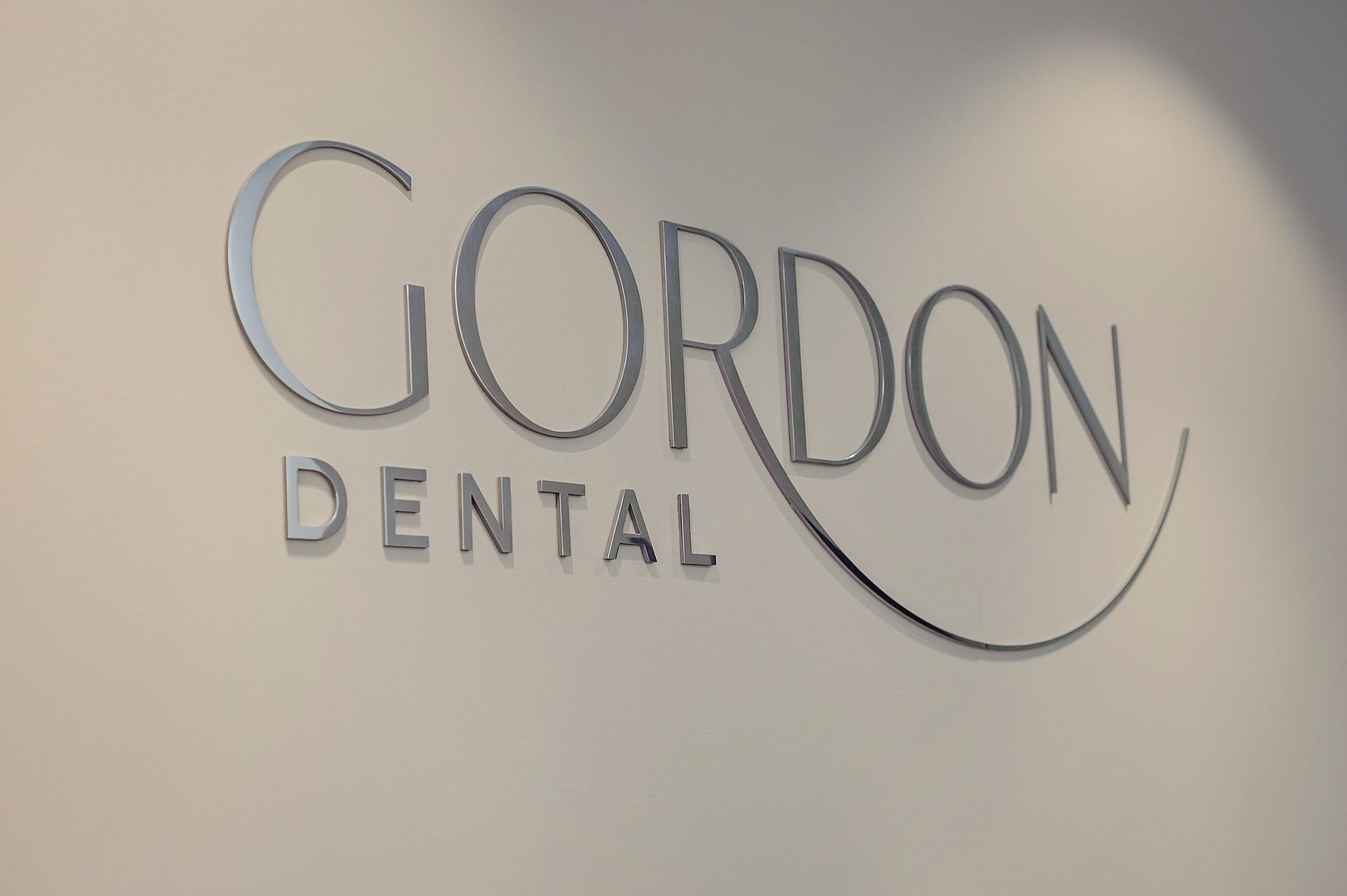 A sign for gordon dental is on a wall