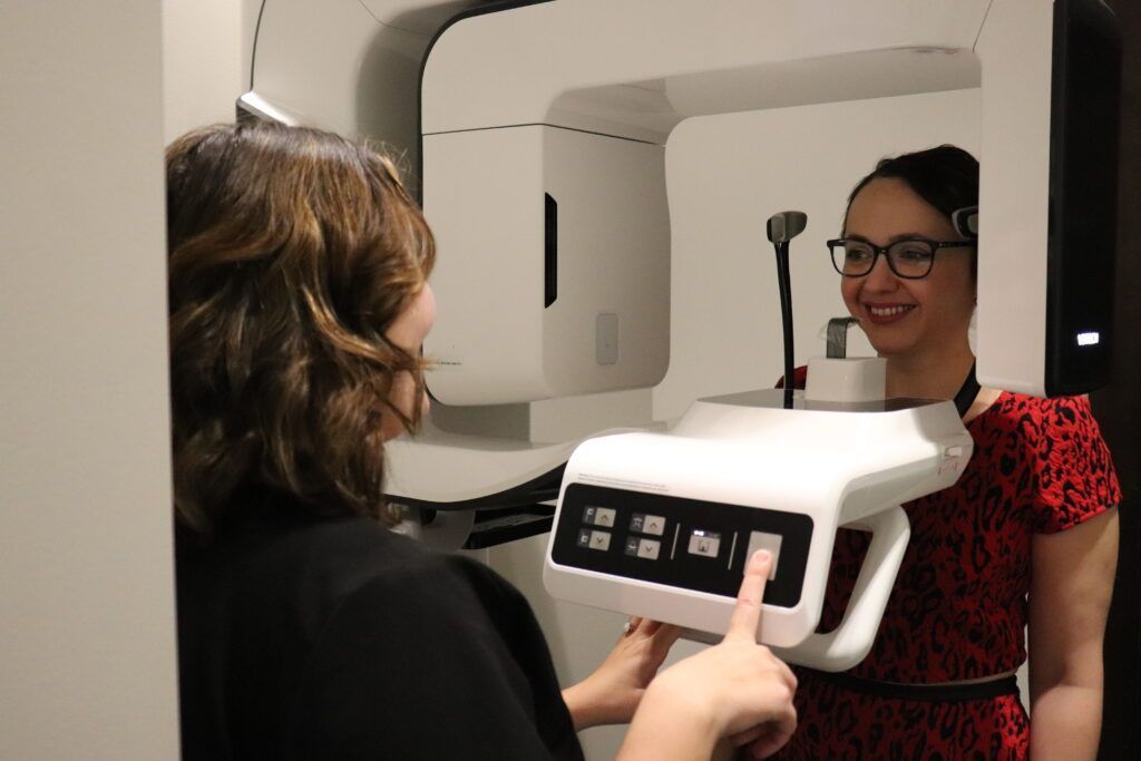 A woman in a red dress is getting an x-ray of her face.