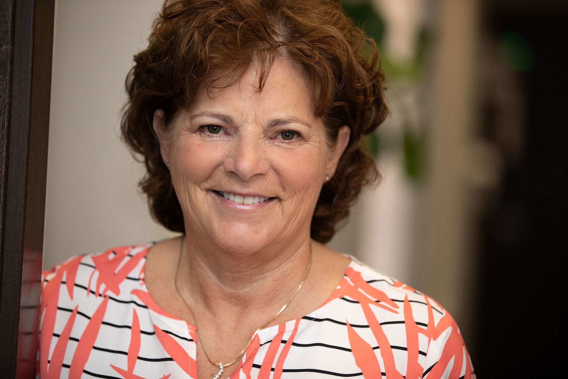 A woman in a striped shirt is smiling for the camera.