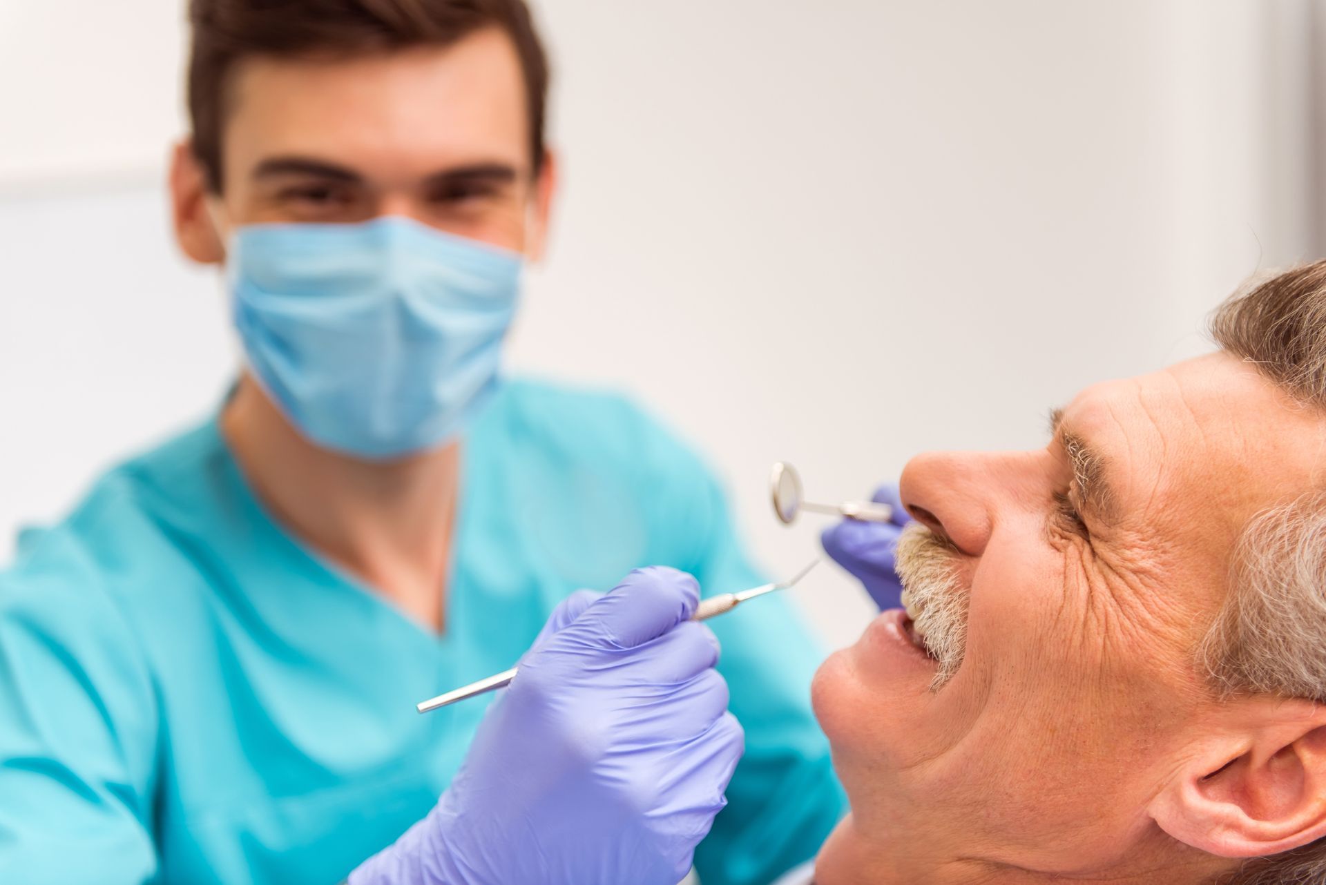 Elderly man at the dental clinic with a dentist in the background. Elderly man at the dental clinic with a dentist in the background.