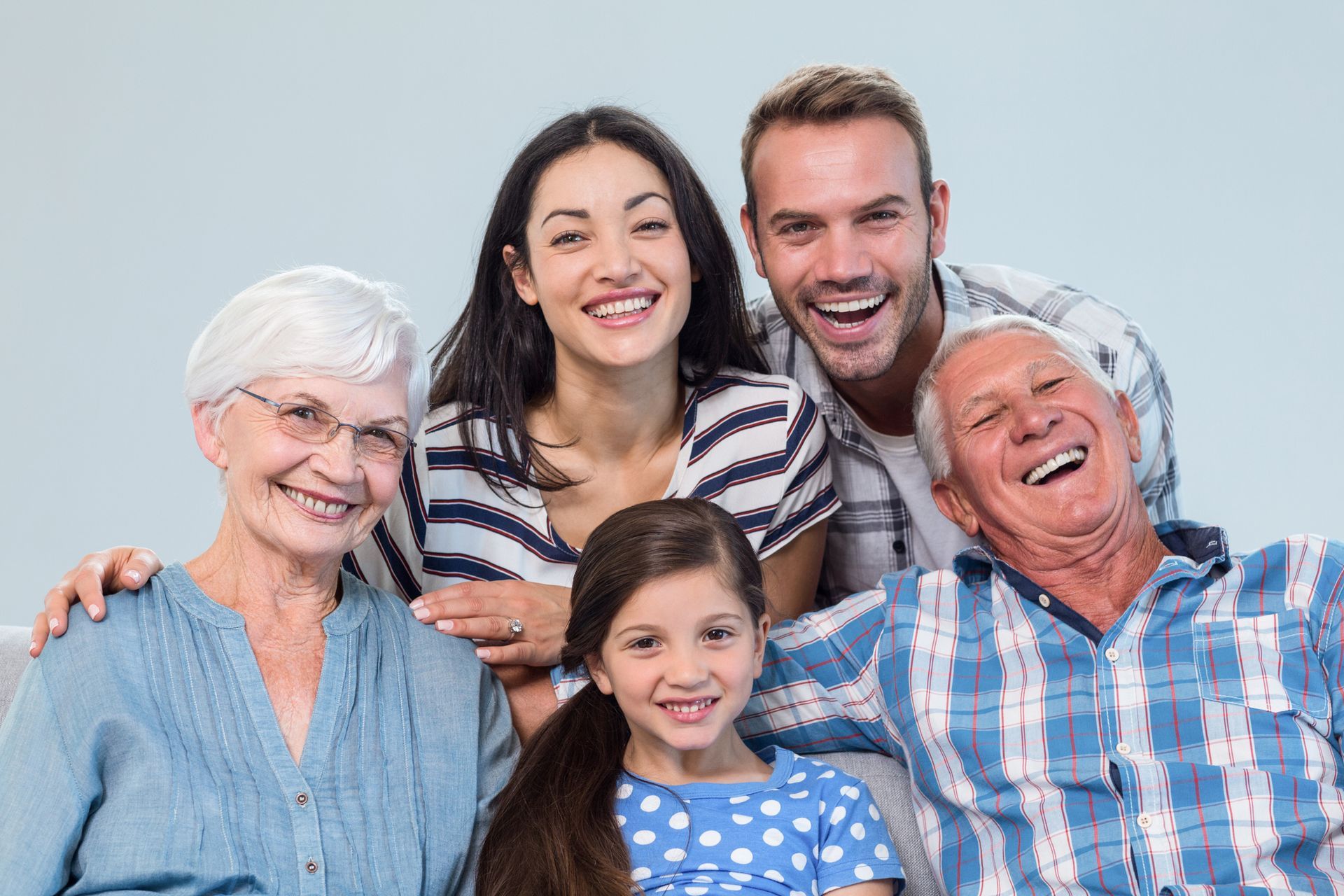 A happy family smiling with a blue background. A happy family smiling with a blue background.