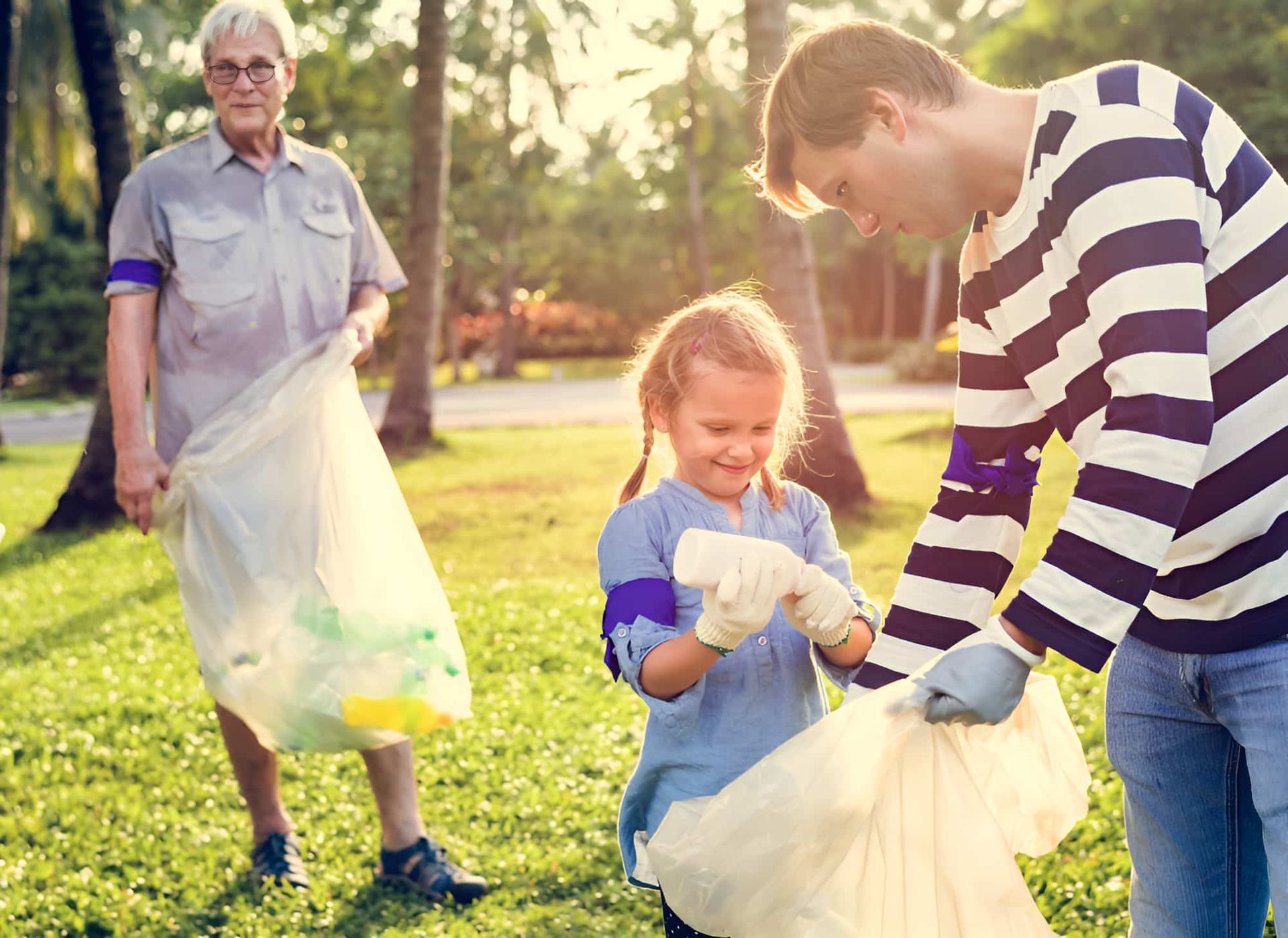 A Man And A Little Girl Are Picking Up Trash In A Park — North Queensland Recycling Agents In Bungalow, QLD
