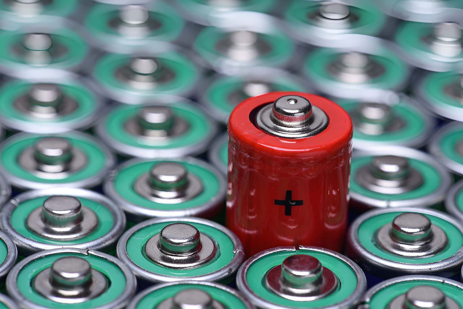 A Red Battery With A Plus Sign Is Surrounded By Green Batteries — North Queensland Recycling Agents In Bungalow, QLD