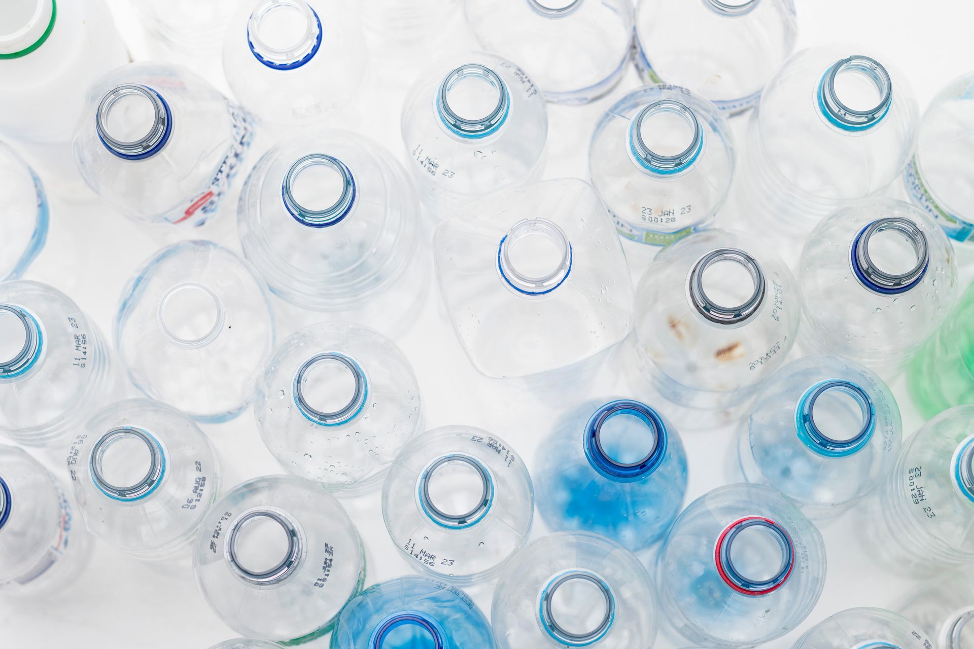 A Person Is Recycling Plastic Bottles And Cans In A Blue Bin — North Queensland Recycling Agents In Bungalow, QLD