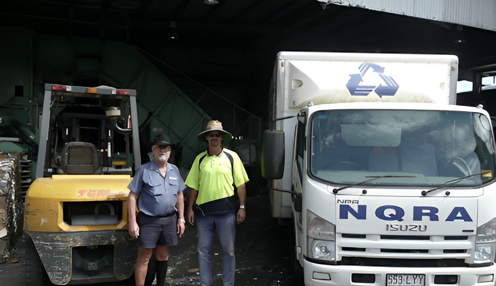 Two Men Standing In Front Of A Truck That Says NGRA — North Queensland Recycling Agents In Bungalow, QLD