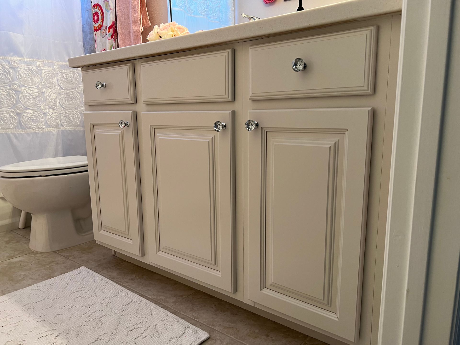 a bathroom with off white cabinets and a toilet