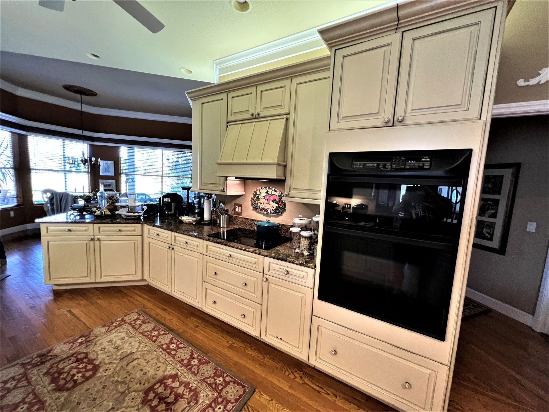 a kitchen with white cabinets and a black oven