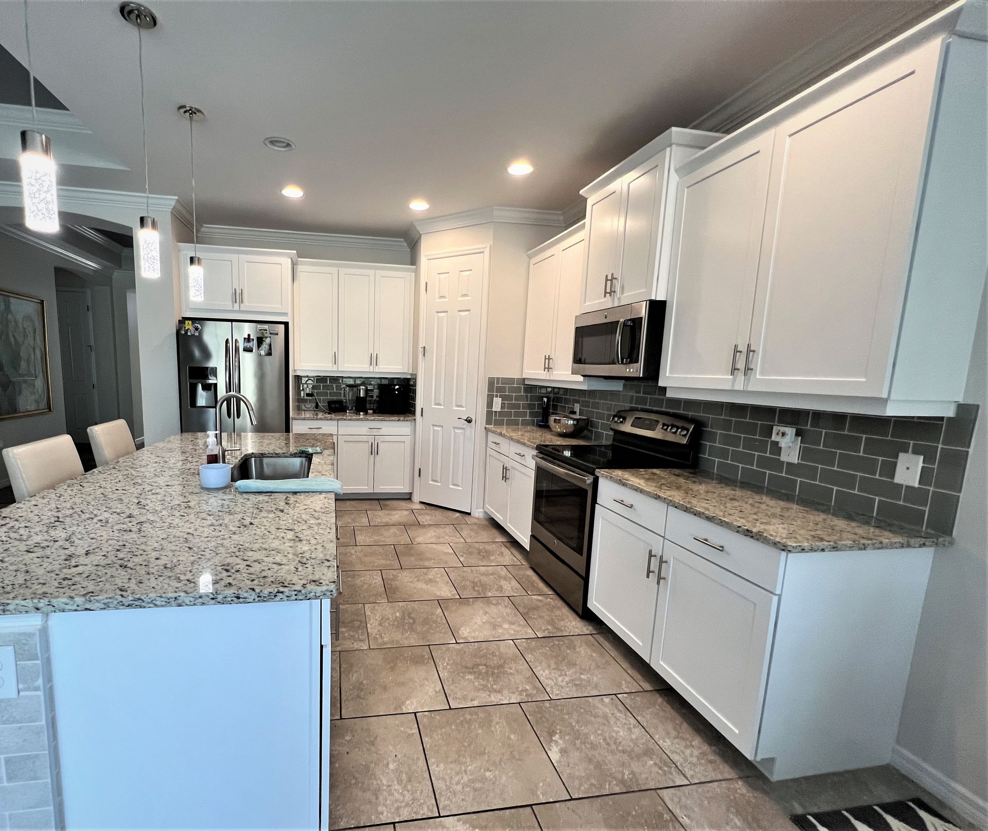 a kitchen with white cabinets and granite counter tops
