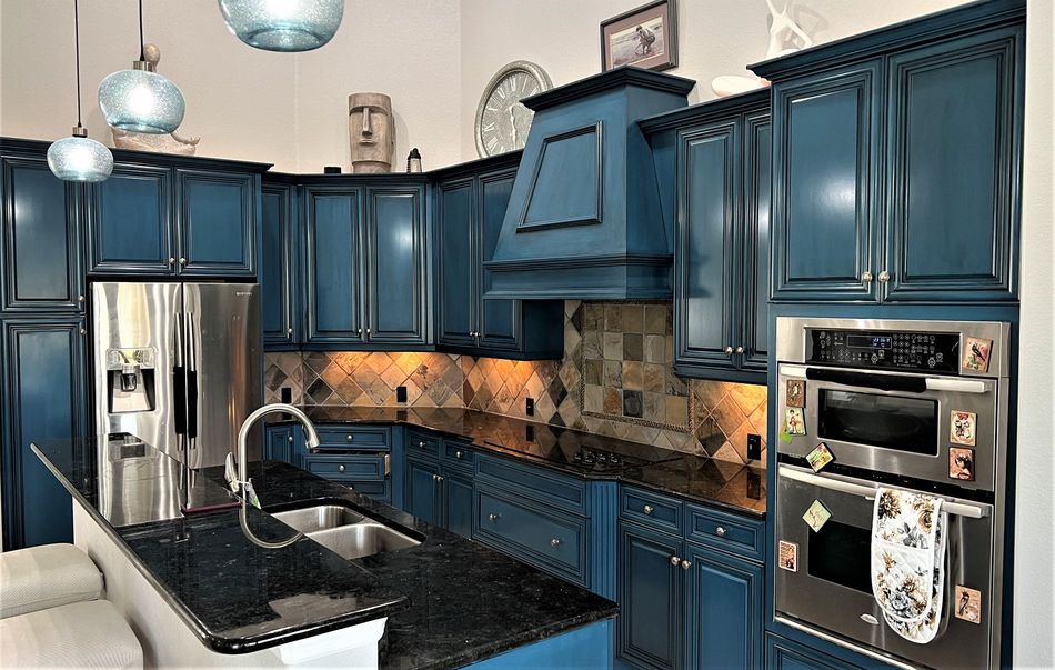 a kitchen with blue cabinets and stainless steel appliances