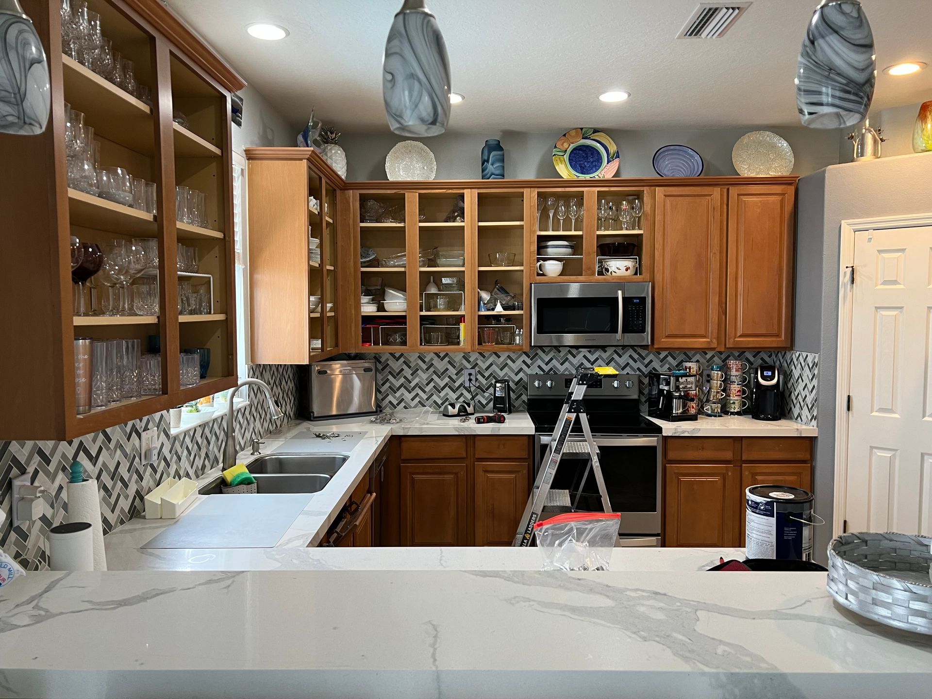a kitchen with a ladder and a bag of paint on the counter