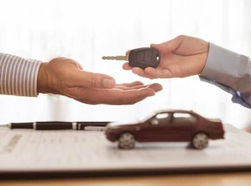 Hand with car key and a car — Auto Insurance in Naples, FL