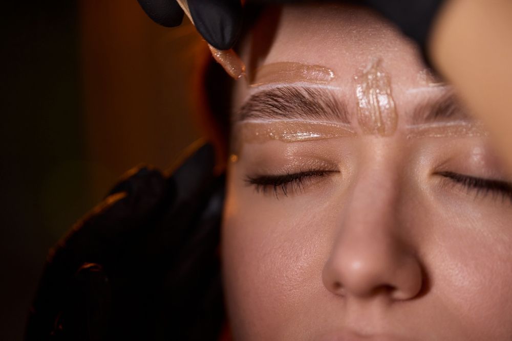 A close up of a woman getting her eyebrows waxed.