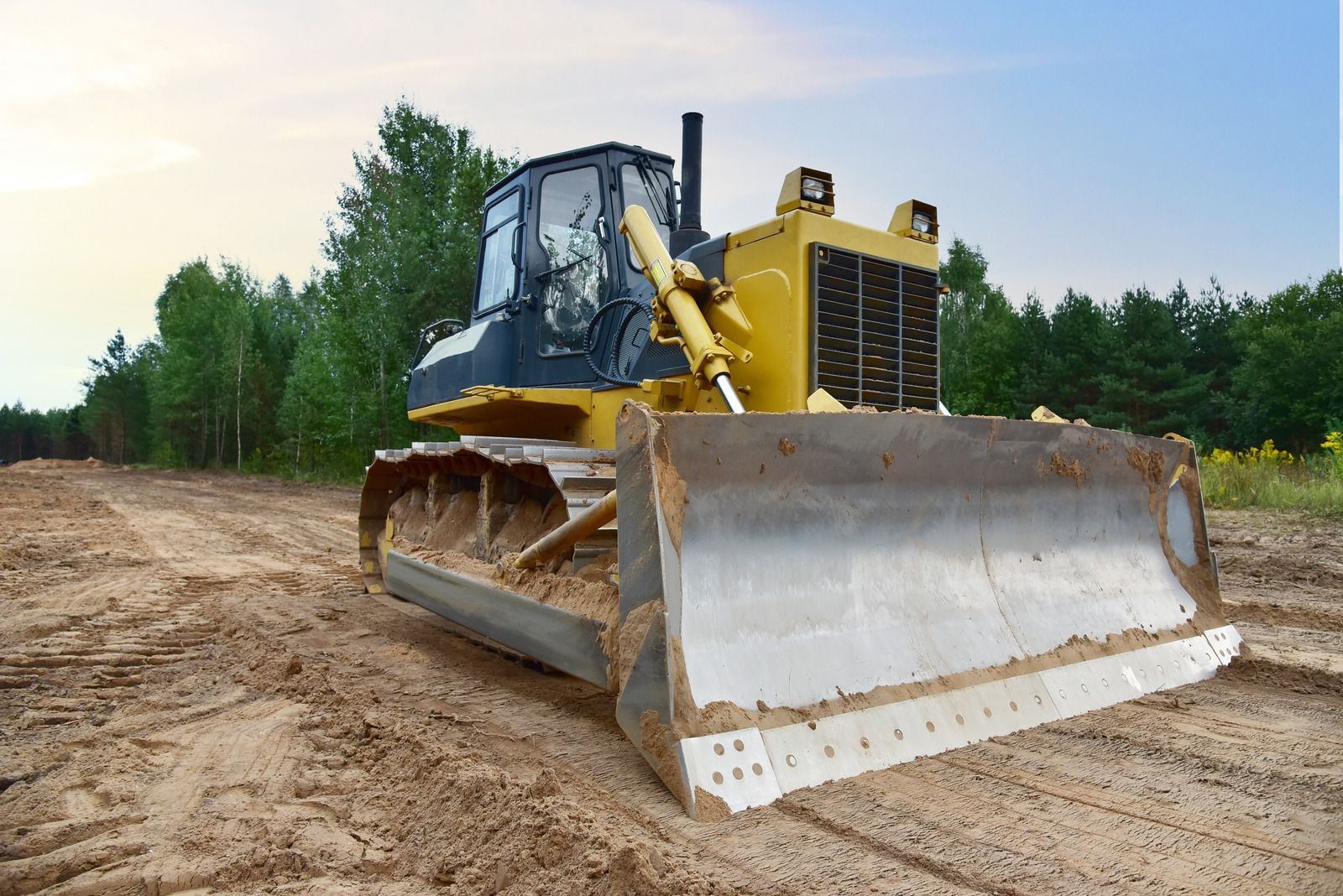 A bulldozer is sitting on top of a dirt road.