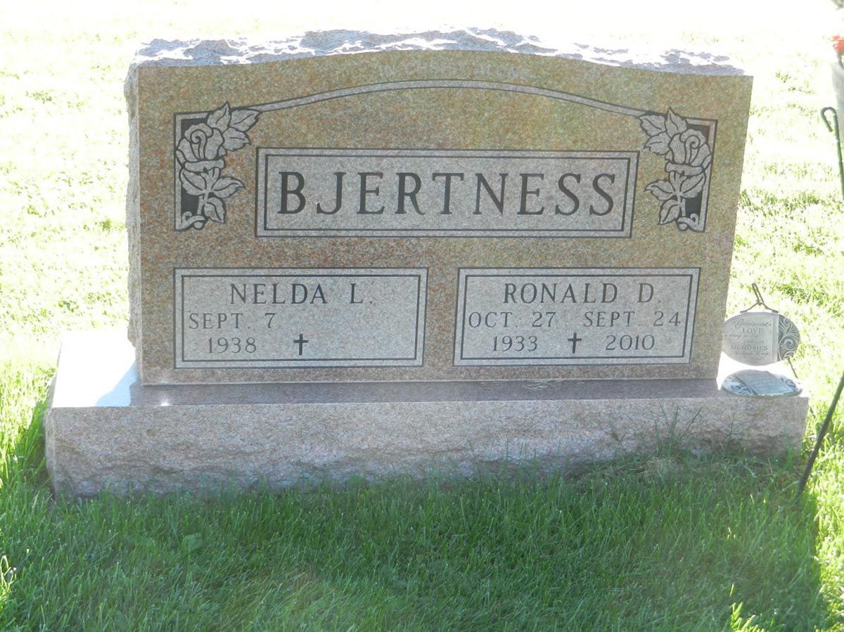 A gravestone in a cemetery with the name bjertness on it
